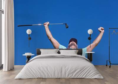 Hole in one. Low-angle shot of a mature male golfer with his arms raised in celebration. Wall mural