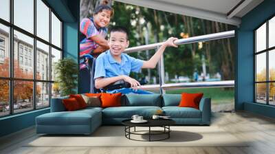 Disabled child on wheelchair is play and learn in the outdoor park like other people, He has adult care and love, Life in the education age of special children, Happy disability kid concept. Wall mural