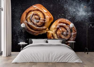 Top view of two freshly baked cinnamon rolls isolated on a rustic background Wall mural