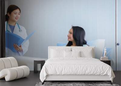 Doctor examining asian woman patient and follow up treatment at hospital Wall mural