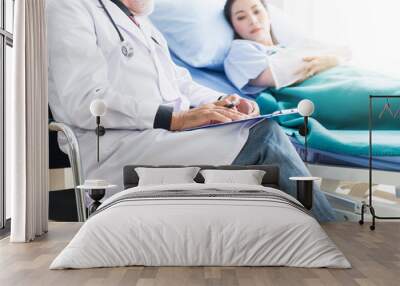 Man doctor examining and talking to asian woman flu patient and follow up treatment at hospital Wall mural