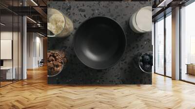 breakfast with chocolate granola, almond flakes and blueberry in black bowl on terrazzo surface Wall mural