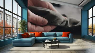 man touching green cotton clothes closeup Wall mural