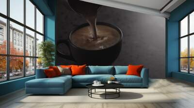 pour hot chocolate into black cup on concrete countertop with copy space under dim light Wall mural