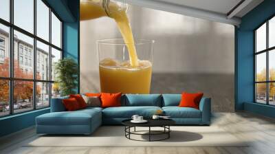 pour orange juice in tumbler glass on oak table with copy space Wall mural