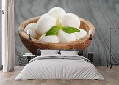 small balls of mozzarella in olive bowl with basil Wall mural