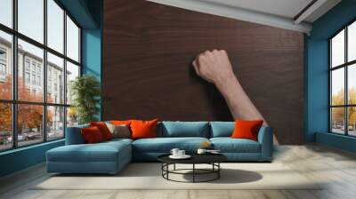 Top view man hand knock on black walnut table with copy space Wall mural