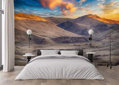 Vast dramatic landscape with a winding dirt road and a Side by Side atv off in the distance. Wall mural