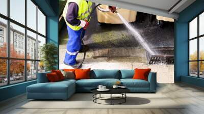 sewer line drainage  by utilities workers with hose with pressurized water of service truck Wall mural