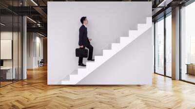 Business man stepping up on stairs Wall mural