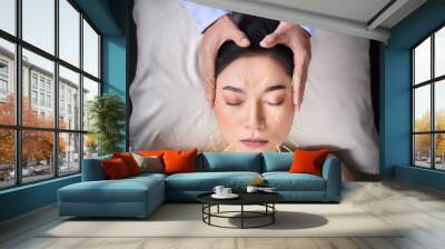 woman undergoing acupuncture treatment on face Wall mural