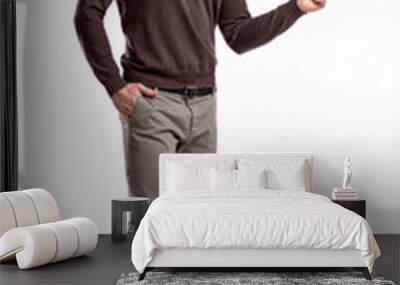 A positive young bearded man stands on a white background and point with his finger sideways. Wall mural