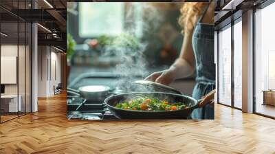 A woman stands in a kitchen, stirring a vegetable stir fry in a pan on the stove, with steam rising from the dish. The setting indicates a cooking or culinary activity. Wall mural