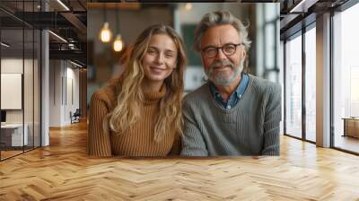 An older man and a younger woman enjoying time together in an office space Wall mural