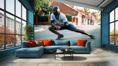 Active young black man stretching on the street Wall mural