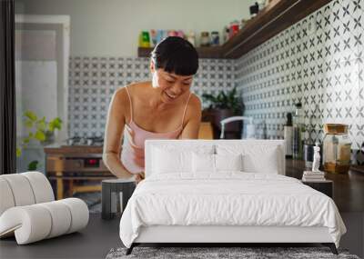 Asian woman unloading dishwasher in modern kitchen Wall mural