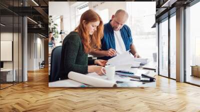 Diverse pair of architects working on a project in a modern office Wall mural