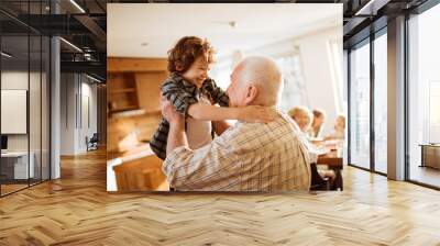 Grandfather embracing his grandson at home Wall mural