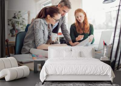 Group of people working together on a project in a startup company office Wall mural