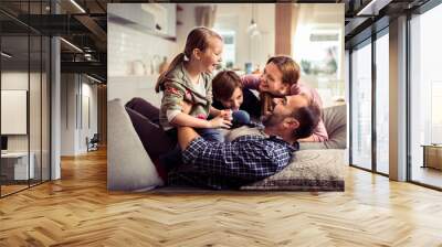 Happy family having fun on the couch at home Wall mural