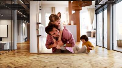 Happy young dad having fun with his kids on the floor at home Wall mural