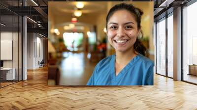 Portrait of a smiling young Hispanic nurse in scrubs at hospital Wall mural