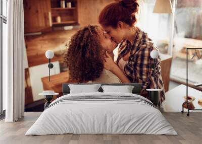 Romantic couple kissing in cozy home kitchen Wall mural