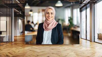 Smiling portrait of an arabic businesswoman wearing a hijab working in a startup company in a modern business office Wall mural