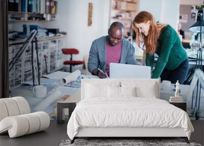 Two diverse designers working together on a project in a startup company office Wall mural