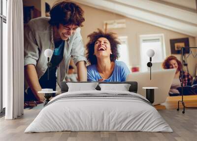 Two young people studying together at home and using the laptop Wall mural