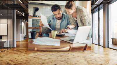 Worried young Caucasian couple going over their bills and home finances in the morning in the kitchen Wall mural