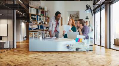 Young and diverse group of architects working on a project together in a startup company office Wall mural