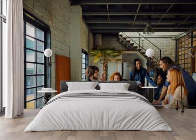 Young and diverse group of coworkers working on a project and having a meeting in a startup company office Wall mural