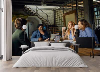 Young and diverse group of coworkers working on a project and having a meeting in a startup company office Wall mural