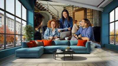 Young and diverse group of designers having a meeting in an office while working in a startup company Wall mural