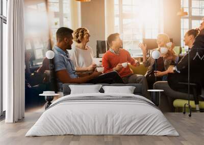 Young and diverse group of people having a meeting after work in the startup company office Wall mural