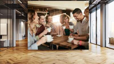 Young and diverse group of people having coffee together at a cafe in the city Wall mural