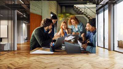 Young entrepreneurs collaborating on new project in modern office Wall mural