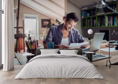 Young man working from home on his laptop Wall mural