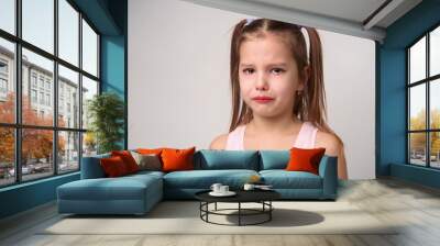 Crying child girl against white background Wall mural