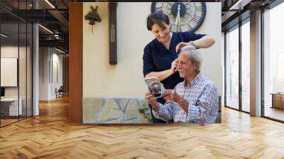 Professional helpful caregiver and a senior man during home visit Wall mural