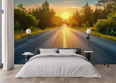 Long, empty road with bright sunrise, clear sky, and surrounding trees Wall mural