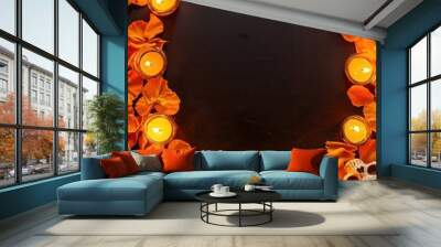 A dark background surrounded by orange petals, candles, and decorative skulls, creating a vibrant and atmospheric setting. Wall mural