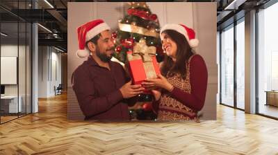 Joven pareja con árbol de navidad en fiestas estilo mexicano Wall mural