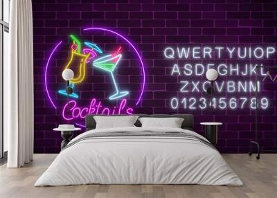 Neon cocktails bar sign with alphabet and two glasses of cocktails. Glowing gas advertising with glasses of alcohol. Wall mural