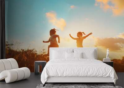 Happy children silhouettes on summer meadow running and jumping : Generative AI Wall mural