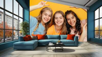 happy teen girls in casual shirt having fun showing peace gesture on yellow background childhood : Generative AI Wall mural