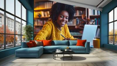 Portrait of smiling woman sitting at desk using laptop and writing in notebook taking notes watching tutorial lecture or webinar studying online at home looking at screen free copy spa : Generative AI Wall mural