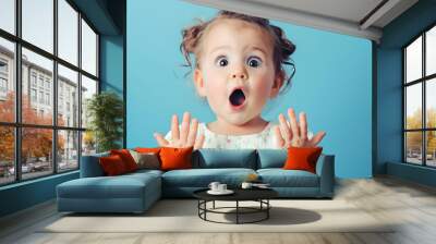 Portrait of surprised cute little toddler girl child standing isolated over blue background Looking at camera hands near open mouth : Generative AI Wall mural