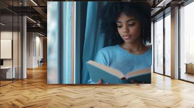 Pretty african american girl in homewear reading book sitting on windowsill Beautiful Afro woman happily reading a novel in cozy room Education and knowledge concept : Generative AI Wall mural